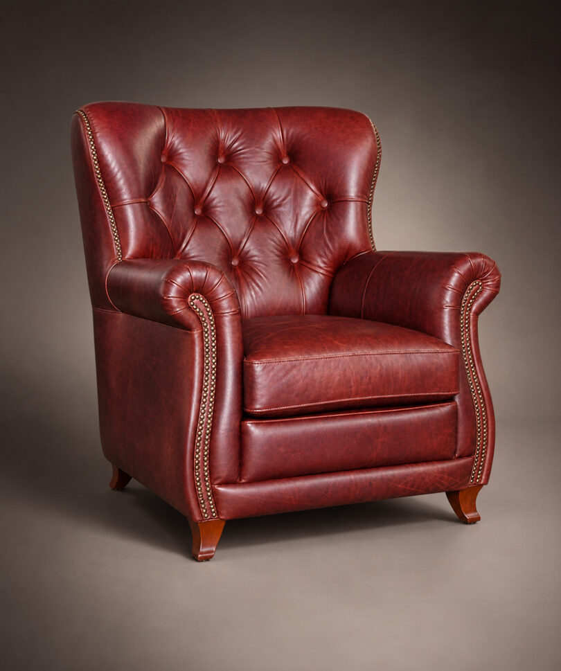 Red leather Armchair WINSTON with button tufting and decorative nailhead trim, three-quarter view